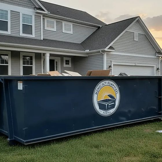A Monocacy Dumpster truck setting a roll-off container down on a Frederick County driveway